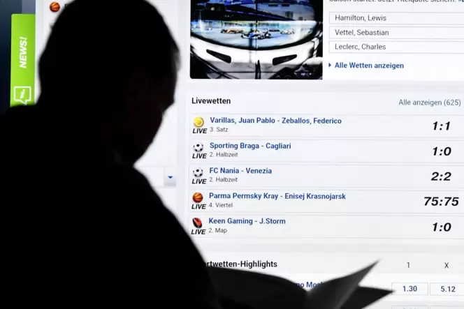 Glück gehabt? Ein Mann steht vor einem Bildschirm eines Sportwetten-Anbieters.