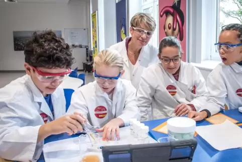Wohlwollend beobachtet von BASF-Vorstandsmitglied Melanie Maas-Brunner experimentieren die Jungforscher im Kids-Lab. 