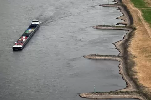 Ein Frachtschiff fährt bei Niedrigwasser auf dem Rhein. Die Klimakrise könnte nach einer Umfrage eine dauerhafte Belastung für v