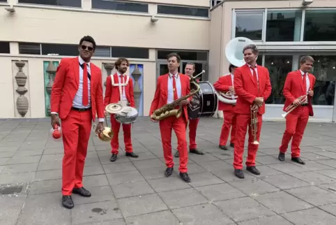 Wegweiser durch die Stadt: Die Marching Band Brass2Go vorm Kulturzentrum Das Haus.