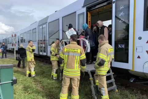 Feuerwehrleute helfen den 21 Insassen aus dem Zug. 