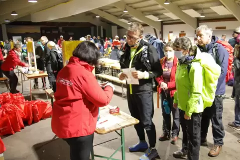 Sonja Spieß (links) verteilt in der Falkenburghalle Wilgartswiesen die Startnummern für den Wald-Marathon.