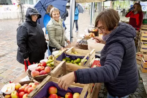 Trotzten dem Regen: Gabriele Lang und Nelli Schramenko (von links) kauften bei Margarete Wollenger Äpfel ein.