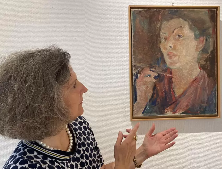 Maria Lucia Weigel, Leiterin des Erkenbert-Museums, mit dem Selbstbildnis von Karin Bruns in der Jubiläumsausstellung im Kunstha