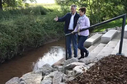 Göcklingens Ortsbürgermeisterin Manuela Laub und ihr Amtsvorgänger Fritz Garrecht an der Steintreppe, die zum Kaiserbach führt. 