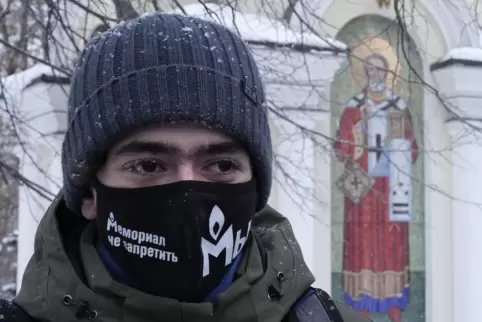 Anhänger der Menschenrechtsgruppe Memorial tragen Gesichtsmasken mit der Aufschrift „Memorial kann nicht verboten werden“.