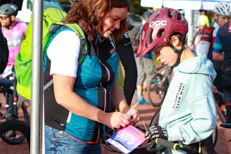 Noch schnell die Startnummer ans Bike heften: In wenigen Minuten geht es los. 