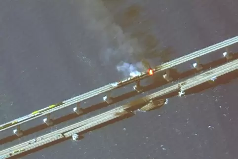 Dieses Satellitenbild zeigt brennende Eisenbahnwaggons und Schäden an der Brücke, die das russische Festland und die Halbinsel K