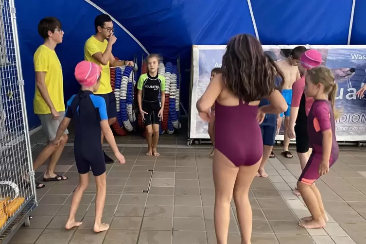 Die Breitensportgruppe von Thien Nguyen (hinten) w&auml;rmt sich im Trockenen auf. Erst dann geht es ins Wasser.