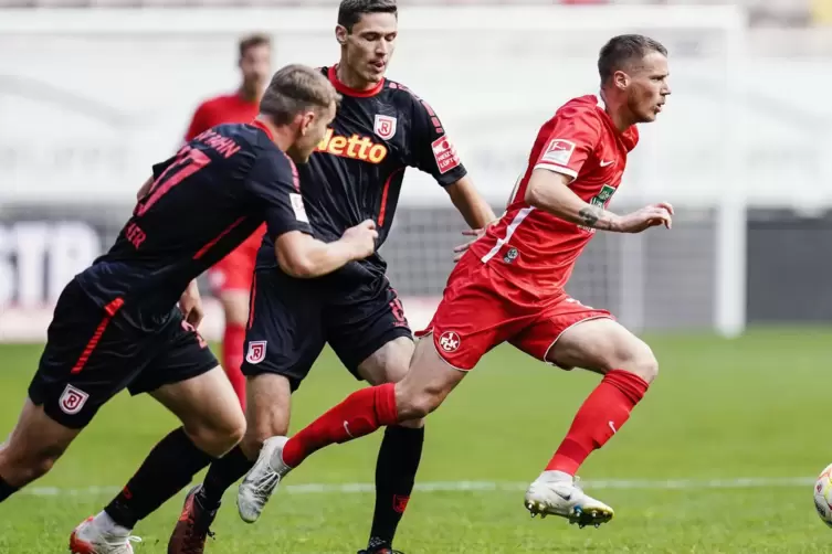 Kaiserslauterns Erik Durm (rechts) sowie Regensburgs Lasse Günther (links) und Regensburgs Maximilian Thalhammer kämpfen um den 