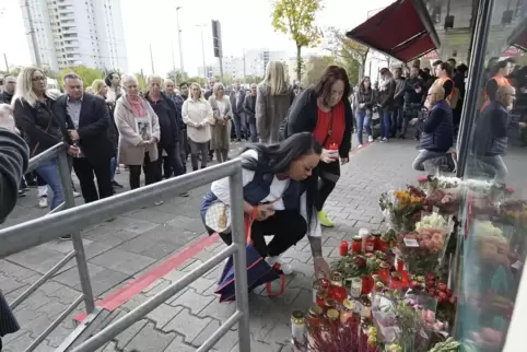 Vor Angehörigen legen Trauernde in der Comeniusstraße Blumen nieder. 