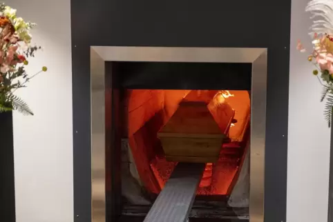 Ein Sarg fährt vollautomatisch in eine der drei Öfen ein. 