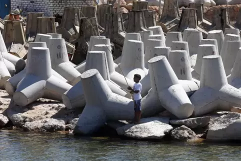 Barrieren gegen den ansteigenden Meeresspiegel: Ein Junge angelt in Alexandria.