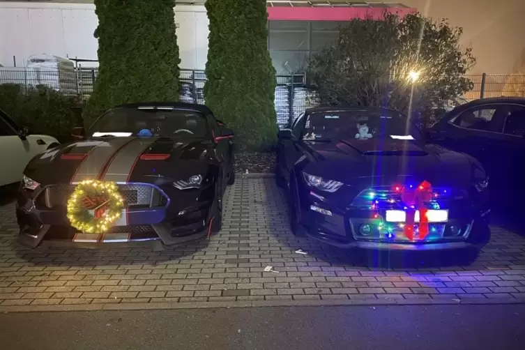 Zwei Muscle-Cars mit Weihnachtsschmuck.