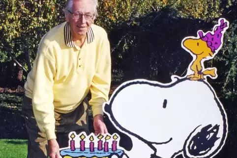 Charles M. Schulz bei einer Geburtstagsfeier mit Snoopy und Woodstock. 