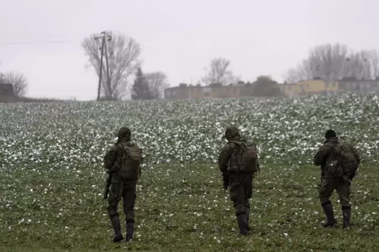 Polnische Soldaten suchen auf einem Acker im Dorf Przewodow nahe der ukrainischen Grenze nach Wrackteilen nach einem Raketeneins