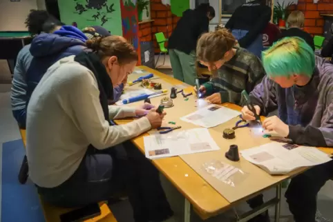 Im Jugendhaus One löten die Teilnehmer unter Anleitung von Studenten konzentriert ihr Diodenmännchen zusammen. 