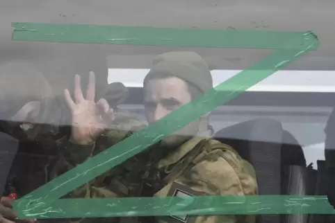 EIn russischer Soldat hinter einem Busfenster mit dem Symbol für die „Spezialoperation“. 