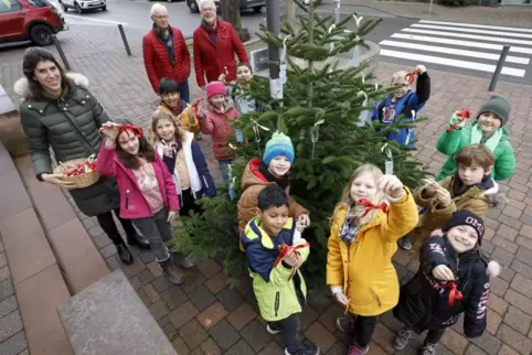 Die Kleinen machen gerne mit: Grundschulkinder schmücken einen der Weihnachtsbäume. 