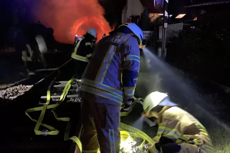 Die Feuerwehr rollt die Wasserschl&auml;uche aus. 