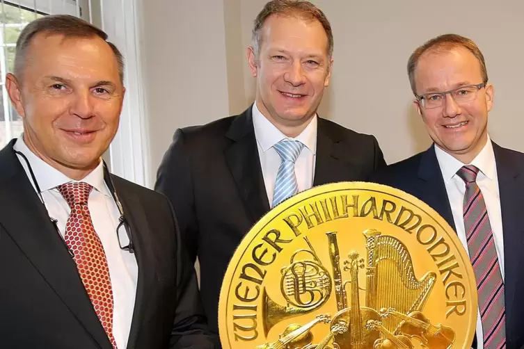 Mit einer Goldmünze und Mitarbeiter Stephan Nagel: Dirk Borgartz (links) und Till Meßmer (rechts). 