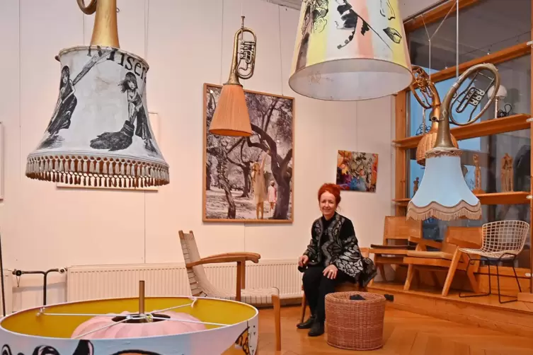 Susanne Wadle unter ihren Lampen, im Hintergrund Fotos von Ruth Habermehl.