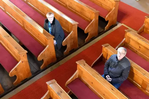 Pfarrerin Julia Heller und Jürgen Bohl testen die sensorgesteuerten Heizkissen in der protestantischen Kirche in Wachenheim. 
