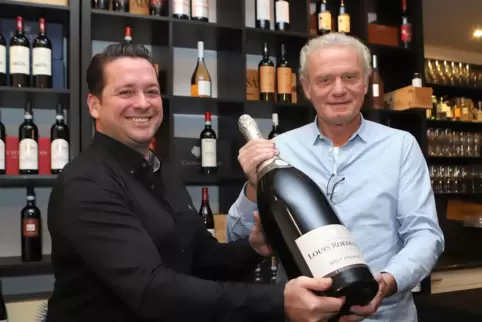Adriano Casella (links) und Hans-Peter Briegel verkaufen Gläser einer Sechs-Liter-Champagner-Flasche für den guten Zweck.