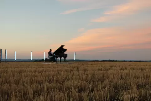 Der Homburger Pianist Erlo Wagner spielt für sein Musikvideo auf dem Acker zwischen Waldmohr und Breitenbach.