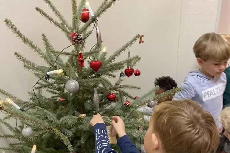 Der Weihnachtsbaum wird mit Anh&auml;ngern aus selbstgesch&ouml;pftem Papier geschm&uuml;ckt.
