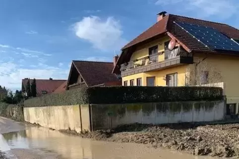Schlammige Brühe: Der Wirtschaftsweg führt an einer Häuserzeile vorbei. 