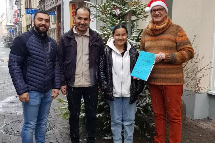 Holiday-Park-Ticket als Geschenk an die Mohamads: Firmenvertreter Angelo Ietro (links) und Mathias Münzenberger bei der Übergabe