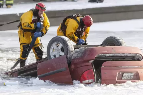 USA, Kansas City: Feuerwehrleute bergen ein Auto, das in eine Fluss gestürzt ist. Ein arktisches Sturmtief bringt über die Weihn