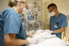 Oberarzt Michael Zimmer untersucht ein Neugeborenes nach einem Kaiserschnitt.