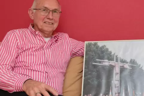 Wolfgang Lenhart mit einem Foto der Segensfeier am Kreuz 2000 im Stadtpark von Martin Schöneich.