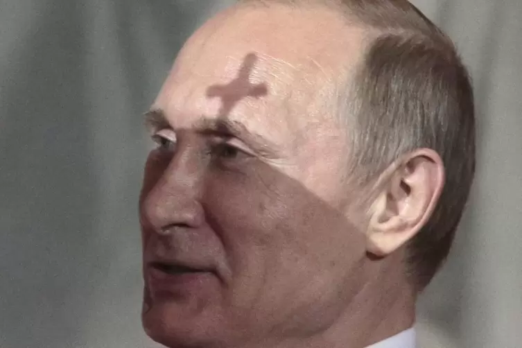 Das Kreuz des Patriarchen Kyrill wirft bei einem Gottesdienst einen Schatten auf die Stirn Wladimir Putins. 