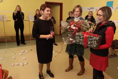 Bei der Feier des 40. Dienstjubiläums als Kita-Leiterin erhält Christine Bücklein (schwarzes Kleid) von Tanja Hieske (links) und