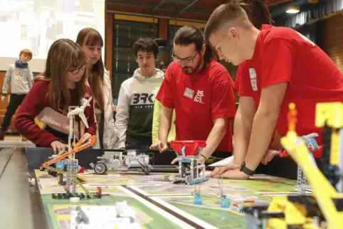 Der Roboter von Leonie Kirf, Finja Bernhard und Maximilian Oberschachner (von links) wird im Wettkampf genau von den Schiedsrich
