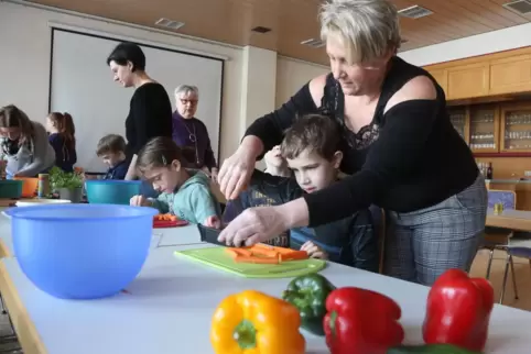 Anja Witting hilft Leo beim Schneiden von Gemüse. Zuvor haben die Kinder den „Krallengriff“ gelernt