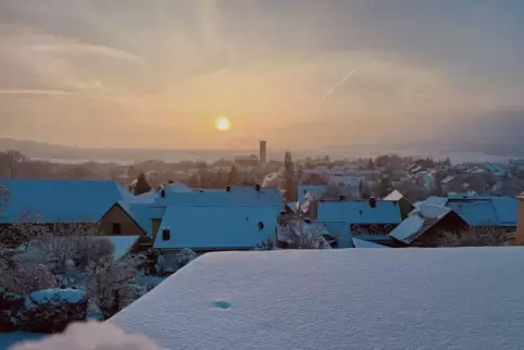 Eine zauberhafte Kulisse bilden die schneebedeckten Dächer in Dreisen vor der aufgehenden Sonne.