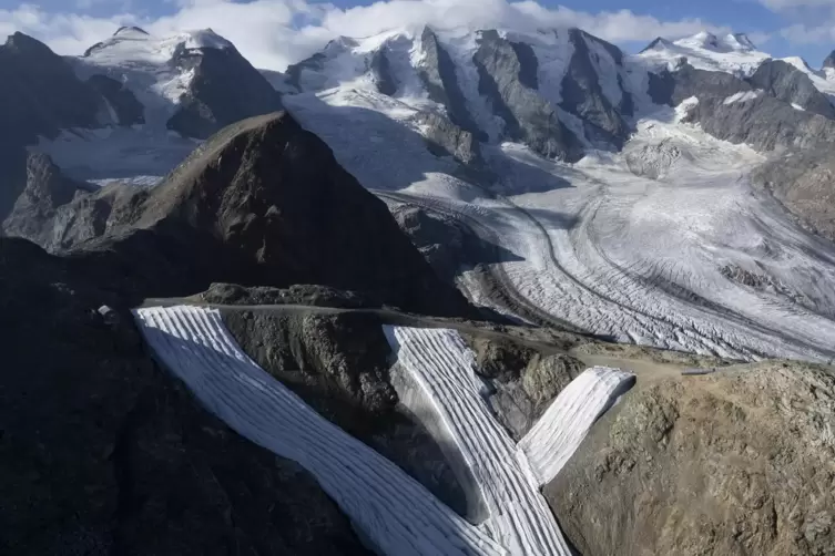 Skipisten vor der schweizerischen Berninagruppe mit Pers- und Morteratschgletscher sind mit Vlies bedeckt. Der Hitzesommer 2022 
