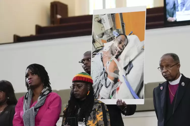 Familienmitglieder und Unterstützer halten ein Foto von Tyre Nichols bei einer Pressekonferenz. Nichols starb, nachdem er von Po