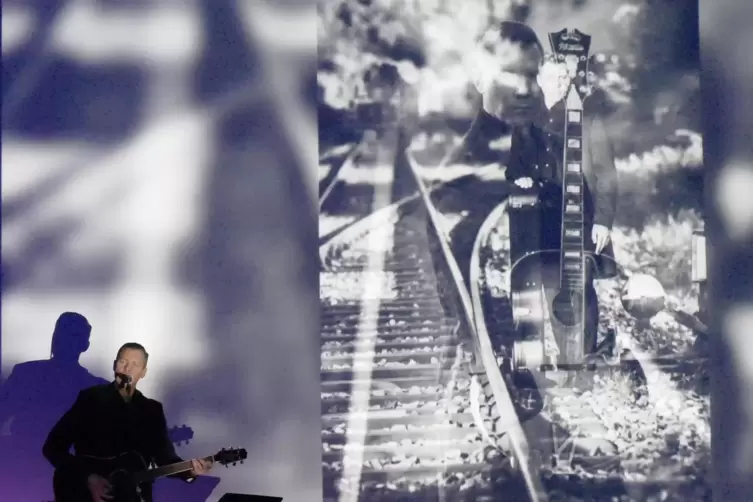 Mark Schlick greift zur Gitarre und spielt Johnny Cash, während ihn Kröherfotos in typischen Cash-Posen zeigen.
