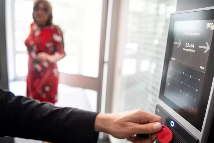 Ein Mitarbeiter erfasst seine Arbeitszeit digital an einem Terminal.