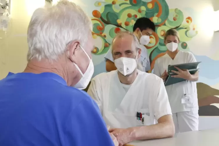 Patient unterhält sich mit Mark Steitz, li dahinter Natthanan Ruksasaeng und Julia Stein