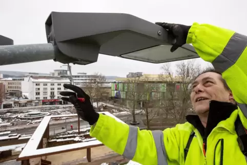 Der Elektroinstallateur Uwe Fischer führt Wartungsarbeiten an einer Straßenlaterne in Kaiserslautern durch.