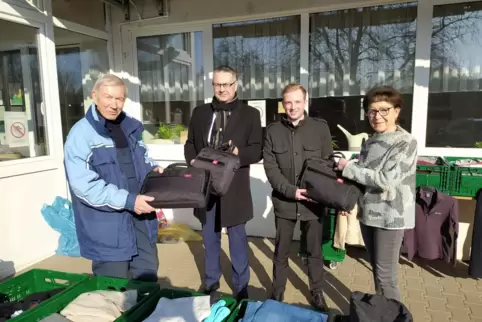 Timo Kreiner (2. von rechts) und Christian Bauchhenß von der VR-Bank Südpfalz übergeben die Laptops an Peter Wolters (links) und
