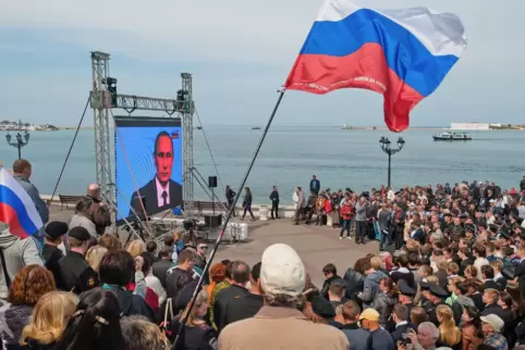 Der Krieg begann nicht erst 2022: Bewohner der eroberten Krim sehen sich 2014 eine Rede Putins an. 