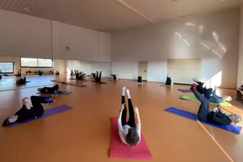Mit Dehnen, Schulterbrücke und Übungen für Bauch und Rücken hält Renate Müller (rechts auf der blauen Matte) ihre Kursteilnehmer