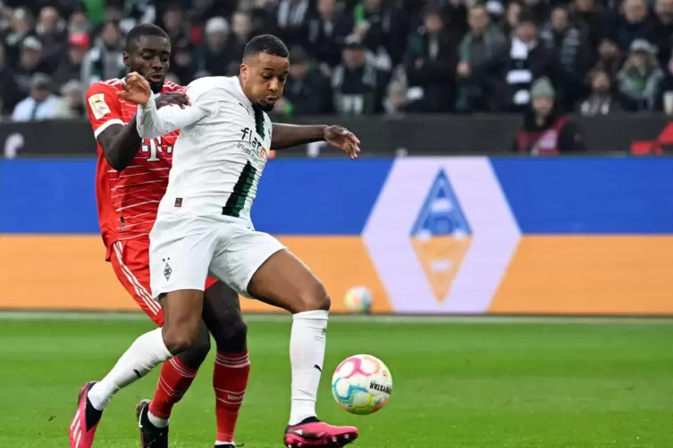 Gleich kommt Alassane Pl&eacute;a zu Fall, Dayot Upamecano touchiert ihn leicht.